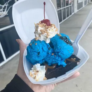 a hand holding a container of ice cream