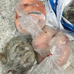 a variety of seafood wrapped in plastic bags
