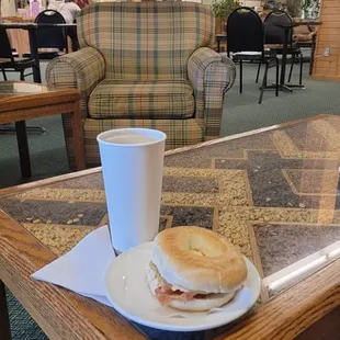 a table with a sandwich and a cup of coffee