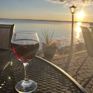 a glass of wine sitting on a table
