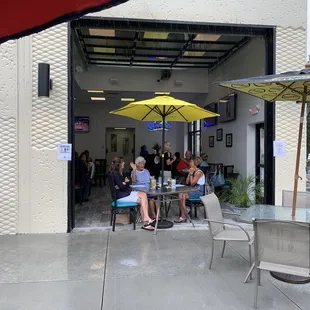 people sitting at tables under umbrellas