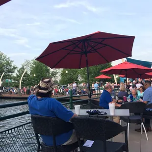 people sitting at tables with umbrellas