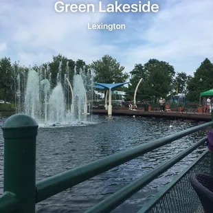a woman sitting on a bench in front of a fountain
