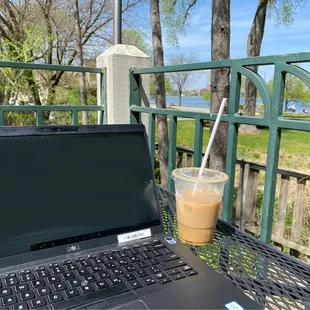 a laptop and a drink on a table