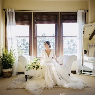 a bride sitting in a chair in front of a window