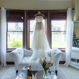 a wedding dress hanging in a window