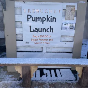 a bench with a sign for pumpkin launch