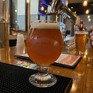 a glass of beer on a bar