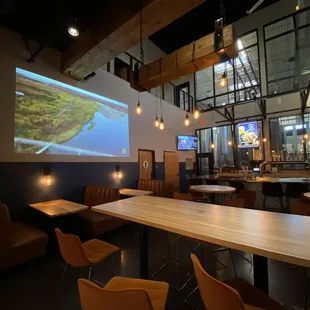 a long table with chairs and a projector screen