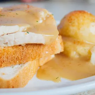 a chicken sandwich with mashed potatoes and gravy