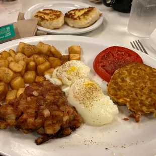 Hash with sliced tomatoes and poached eggs and