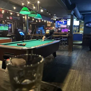 a pool table with a glass of water