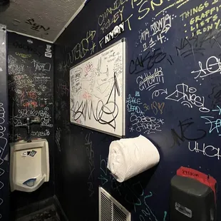a bathroom with graffiti on the walls