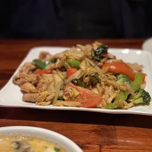 Wide rice noodles, veggies and chicken.