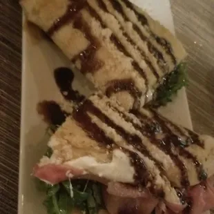 Piandina.. DELICIOUS    Italian flatbread with Goat cheese, Provolone cheese, Prosciutto, Arugula, fig jam finished with balsamic reduction.