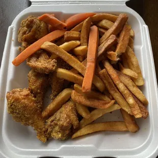 chicken wings and fries in a styrofoam container