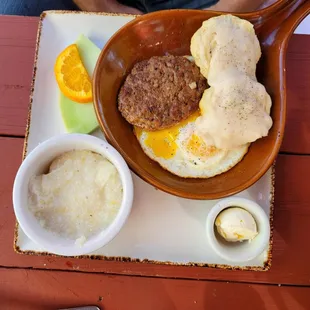 Biscuit and gravy with eggs, sausage and grits.