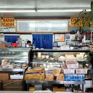 people in a bakery with food on display