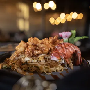 Pad Sen Lobster: Stirred fried soba noodles in garlic sauce, topped with crispy lobster
