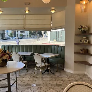 a corner of a restaurant with tables and chairs