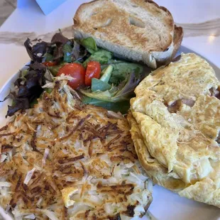 Omelette with hashbrowns, salad, and sour dough toast