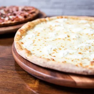 two pizzas on wooden plates