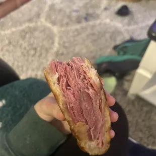 a person holding a half eaten sandwich