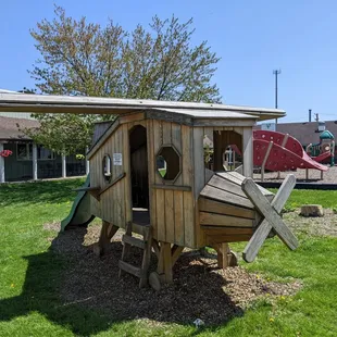 a wooden play structure in a yard