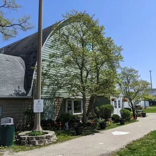 a green barn with a gray roof