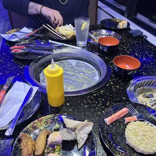 a woman sitting at a table full of food