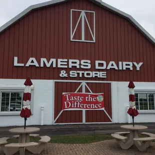 a red barn with tables and umbrellas