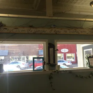 Above the windows. His eye is on the sparrow; I know he watches over me