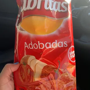 a hand holding a bag of chips