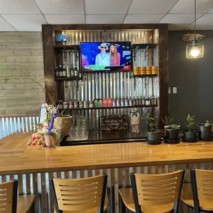 a bar with wooden bar stools and a flat screen tv