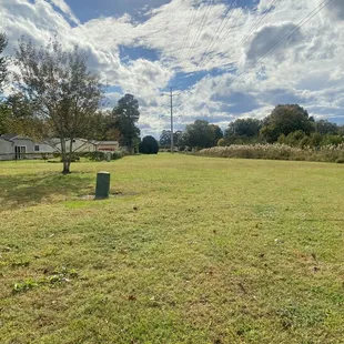 The park seems to be an L-shape with an open field extending to the left behind neighboring homes