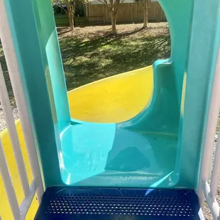 The twirly slide is covered at the top and yet has a standing puddle of water
