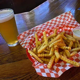 a basket of french fries and a pint of beer