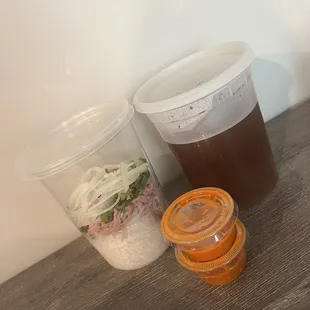 two containers of soup and a container of salad