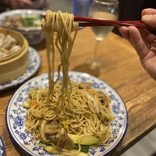 a plate of noodles with chopsticks