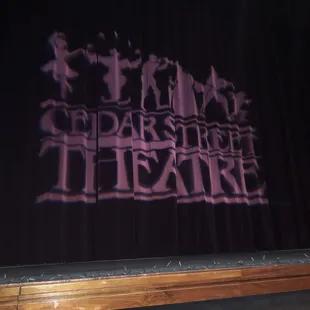 a stage with a shadow projected on the curtain