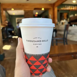 a hand holding a coffee cup