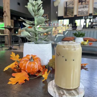 a glass of iced coffee and a pumpkin