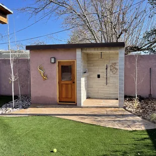 Outdoor sauna with outdoor shower, custom lizard inlay, flagstone pad, synthetic turf, dormant aspen trees planted, larger cobble &amp; grasses