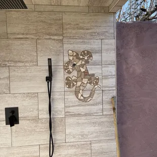 Custom outdoor shower with tile lizard inlay