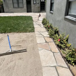 Flagstone path leading from casita to main house back patio, new sod on upper left and leveling sand play area on left