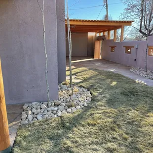 Dormant sod (photographed in winter), new Vega in front, flagstone path leading to side flagstone patio, new pergola and new courtyard wall.