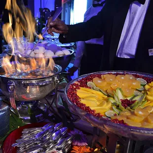 Flaming Bananas Foster and a Mango, Orange and Pomegranate Fruit Platter by Executive Caterers