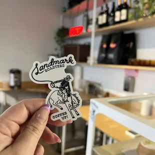 a hand holding a sticker