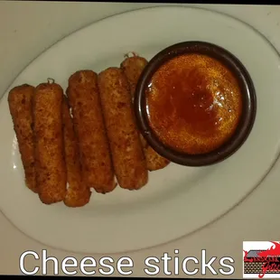 a plate of cheese sticks with dipping sauce