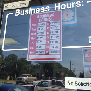 a business hours sign in a window